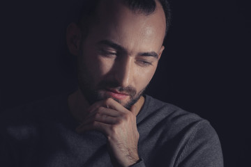 Handsome depressed man on dark background