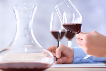 Sommelier estimating red wine in wineglass at tasting