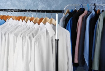 Rack of clean clothes hanging on hangers at dry-cleaning