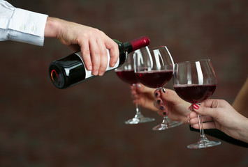 Waiter serving wine to woman at party