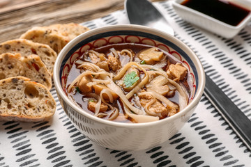 Chicken noodle soup in bowl on napkin