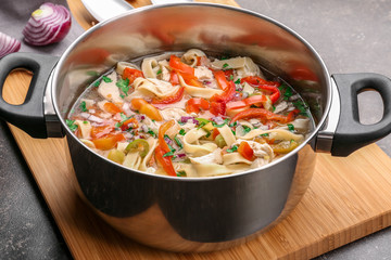 Chicken noodle soup in saucepan on kitchen table