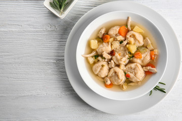 White plate with delicious chicken and dumplings on light background