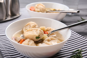 Portions of delicious chicken and dumplings on dining table