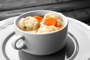 Decorative plate with soup pot of chicken and dumplings closeup
