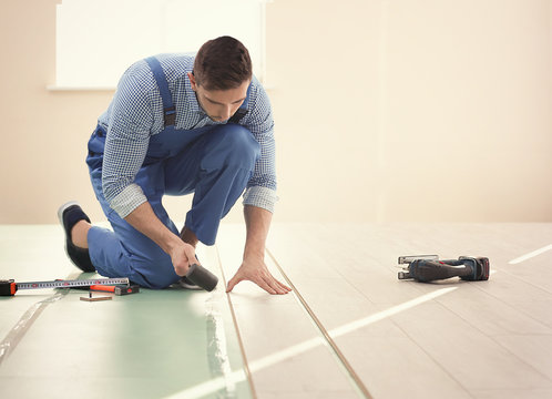 Male worker installing laminate flooring
