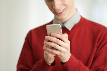 Teenager with mobile phone on blurred background, closeup