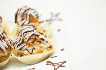 Cream puff cake with filling and chocolate icing. Catering set.