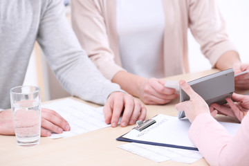 Young couple signing contract at insurance agency office
