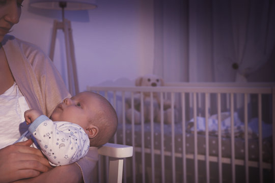 Young woman with cute little baby in evening at home, closeup