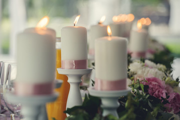 Table served for dinner in living room, close up view. Candles and goblets on a decorated wedding table.