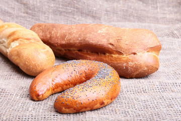 Assorted fresh breads isolated on old sackcloth.