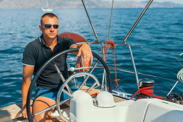 Fototapeta premium Man on his sailing yacht boat.