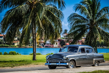 HDR - Schwarzer amerikanischer Oldtimer in der Nähe vom Strand unter Palmen in Varadero Kuba - Serie Kuba Reportage