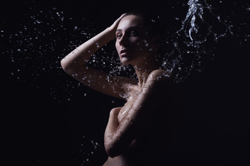 Fototapeta na wymiar Portrait of a beautiful young woman with splashes of water