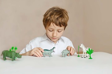 a little child plays with toys animals
