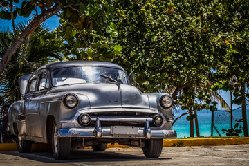 HDR - Silbernder amerikanischer Oldtimer parkt am Strand unter Palmen in Varadero Kuba - Serie Kuba Reportage