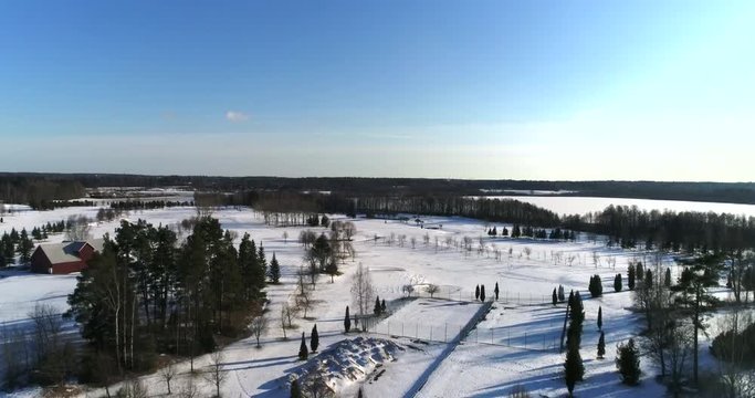 Winter golf course, Cinema 4k aerial landing view of a golf course, near lake Bodom, on a sunny and snowy winter day, in Espoo, Finland