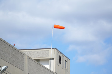 red windsock in the wind on top of the building
