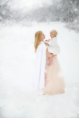 Fototapeta na wymiar Mother and Daughter Happily Hugging in Snow Storm