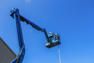 Electric technical repairing street light by boom lift in industrial
