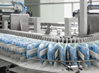 diapers on a conveyor belt closeup. factory and equipment for the production of pampers  - obrazy, fototapety, plakaty