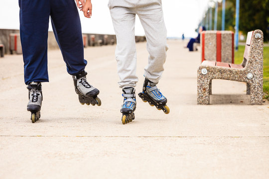 Friends outdoors have fun rollerblading together.