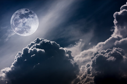 Nighttime sky with clouds and bright full moon with shiny.  Vintage tone effect.