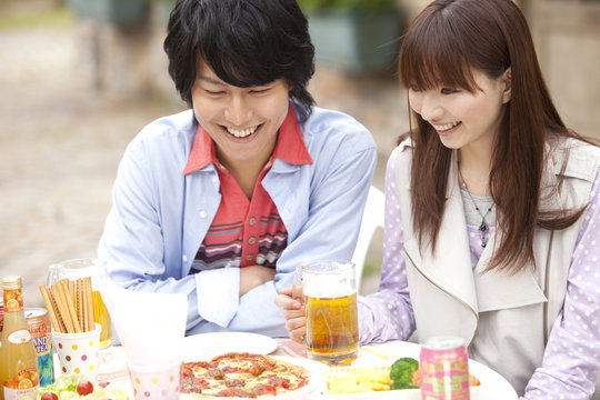 Young couple eating pizza at an outdoor cafe