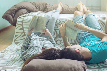 Couple lying on the floor and lifting legs nice reading