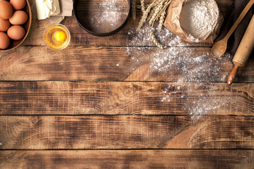 Flour with ingredients for bakery products on wooden background