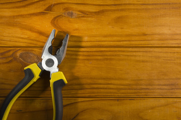 multitool pliers on wooden background