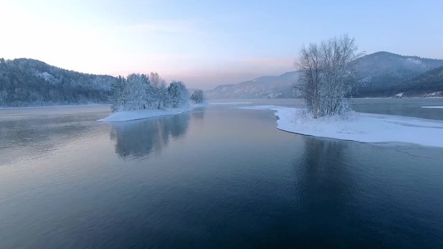 Beautiful winter landscape. Sunset on the river. Great Siberian river Yenisei. Aerial View.