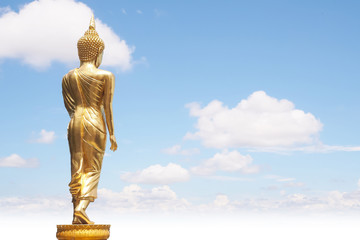 Golden Buddha statue from back side on white cloudy blue sky in sunny day - 140587575