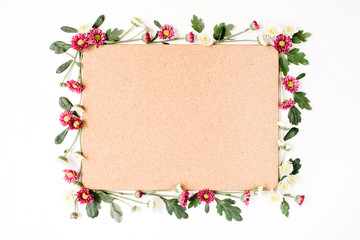 Frame with red and white wildflowers, green leaves, branches and wooden cork tree board on white background. Flat lay, top view. Flower background.