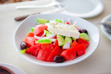 Traditional fresh greek salad, frappe and brusketa served for lunch at outdoor cafe