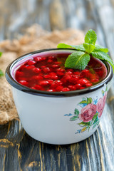 Cranberry jelly and green mint in an enamel mug.