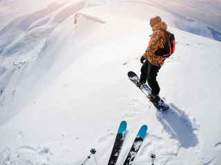 freeriders on steep slope ready to drop in fresh powder snow