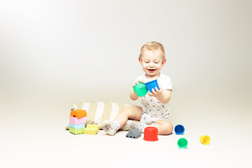 Happy little boy playing with some toys.