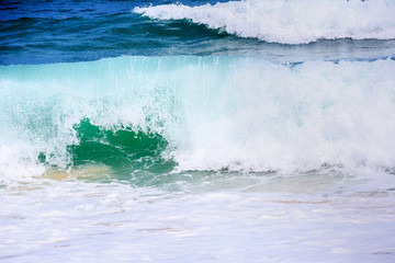 Breaking wave. Empty green wave rolls through to beach with no surfer in view