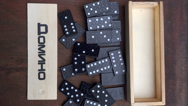 wooden box and black dominoes on the table
