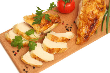 Grilled chicken fillet with tomato on wood background