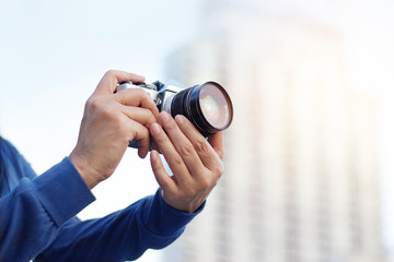 woman holding film camera taking photo in the city