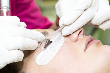 Woman on the procedure for eyelash extensions, eyelashes lamination