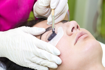Obraz na płótnie Canvas Woman on the procedure for eyelash extensions, eyelashes lamination