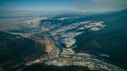 Fototapeta na wymiar flying over the village in the mountains near a forest. aerial photography