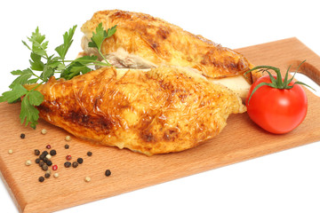 Grilled chicken fillet with tomato on wood background