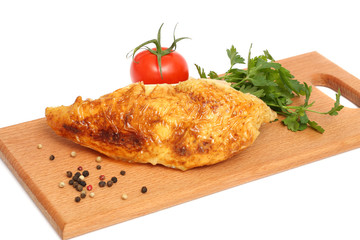 Grilled chicken fillet with tomato on wood background