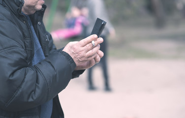 Old man smoking and use his phone