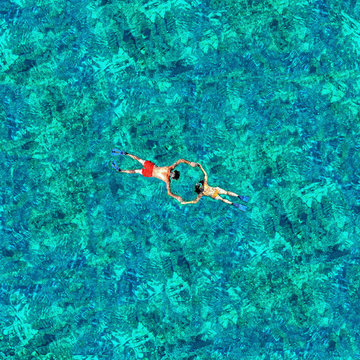 Snorkeling couple in the sea water. View from a drone
